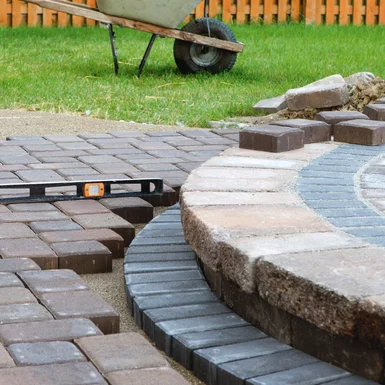 Pflasterarbeiten mit Wasserwaage im Garten