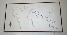 Eine weiße, dreidimensionale Weltkarte in einem Holzrahmen als Wanddekoration.