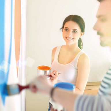 Personen streichen Wand mit Farbe