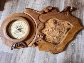 Hölzerne Wanduhr mit Brandmalerei und Vogelmotiv.