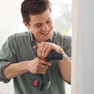 Person bohrt mit Akkuschrauber in Wand