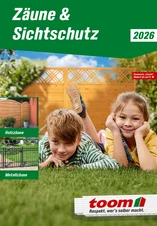 Zwei Kinder liegen im Gras vor einem Sichtschutzzaun aus Holz.