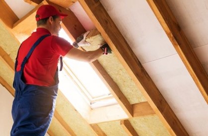 Person beim Dämmen eines Dachstuhls